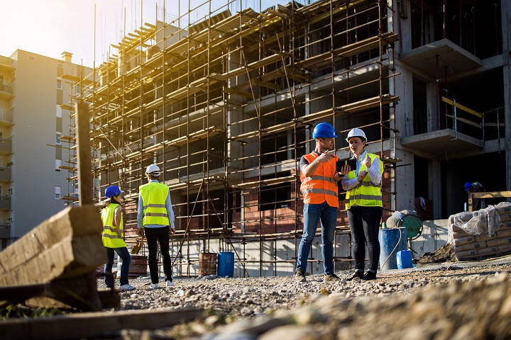 Construction workers on building site discussing plans – CIS mortgage service for contractors and self-employed tradespeople.